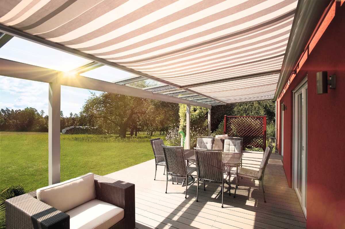 Sonnendurchflutete Terrasse mit Markise und Gartenmöbeln