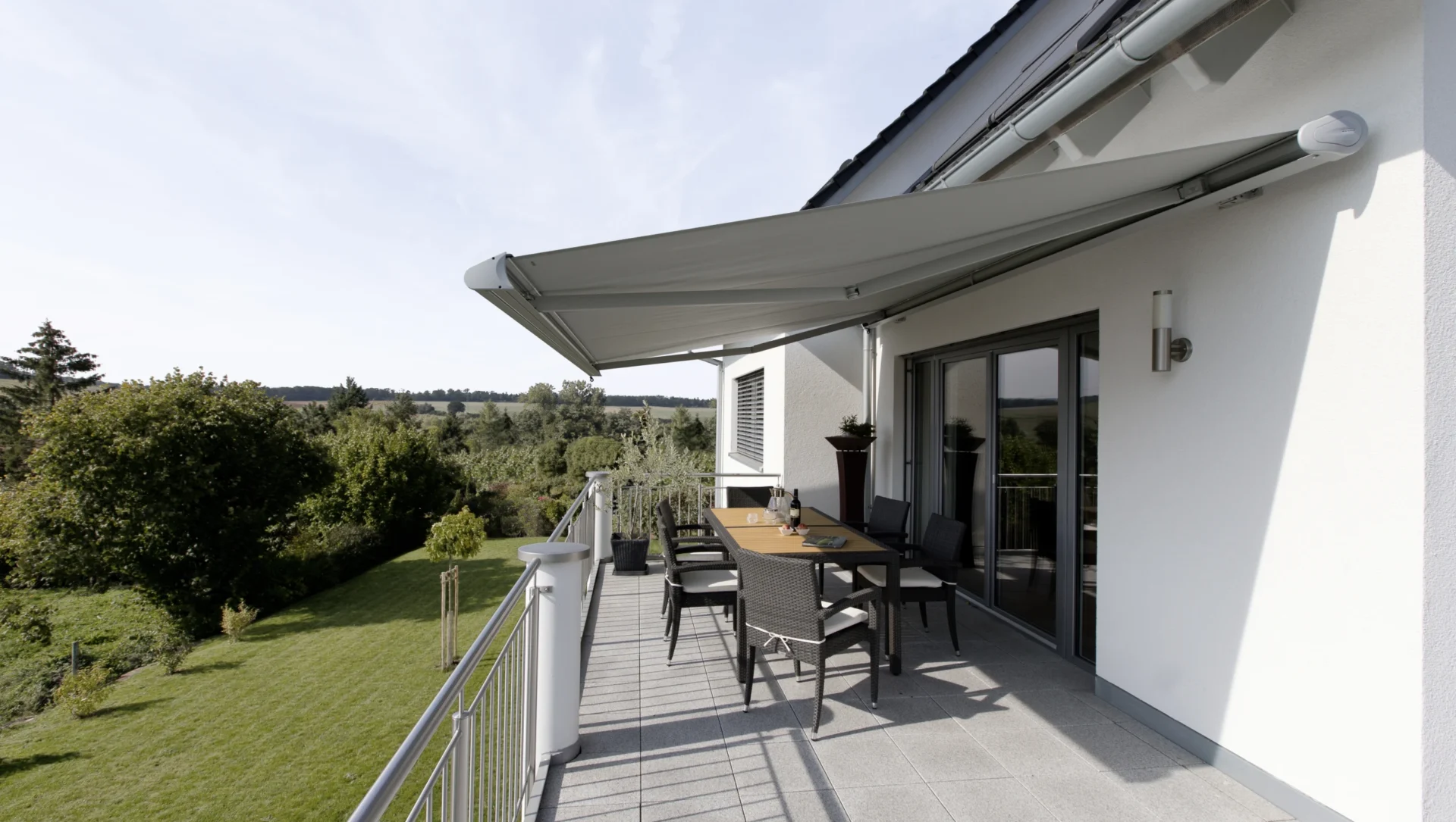 Moderne Terrasse mit Markise und Sitzbereich im Grünen